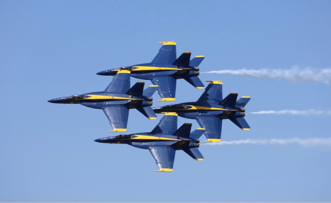The Blue Angels in diamond formation against blue sky